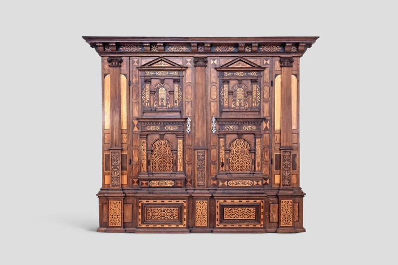Objektabbildung zoomen Reich verzierter Holzschrank mit zahlreichen Elementen der antiken Architektur.