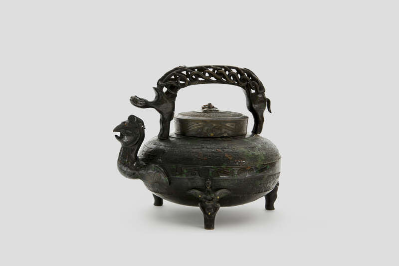 Objektabbildung zoomen Bronzekanne mit einem Ausguss in Form eines Vogelkopfes und einem Henkel in Form eines Drachens.