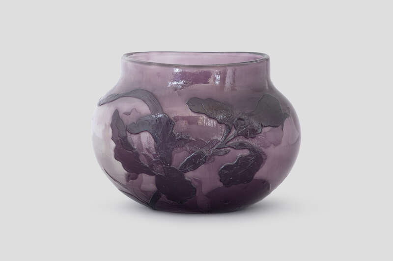 Objektabbildung zoomen Vase mit ovaler Grundform und senkrecht abgesetztem Lippenrand. Auf der Wandung plastische Schwertlilien mit Blättern geätzt.