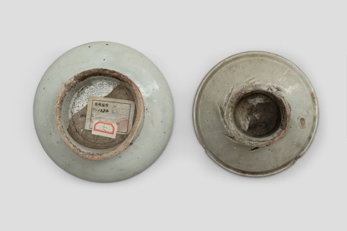Zoom image for the object Die Unterseite der Teller. Der linke, größere Teller trägt einen Aufkleber auf der Unterseite.